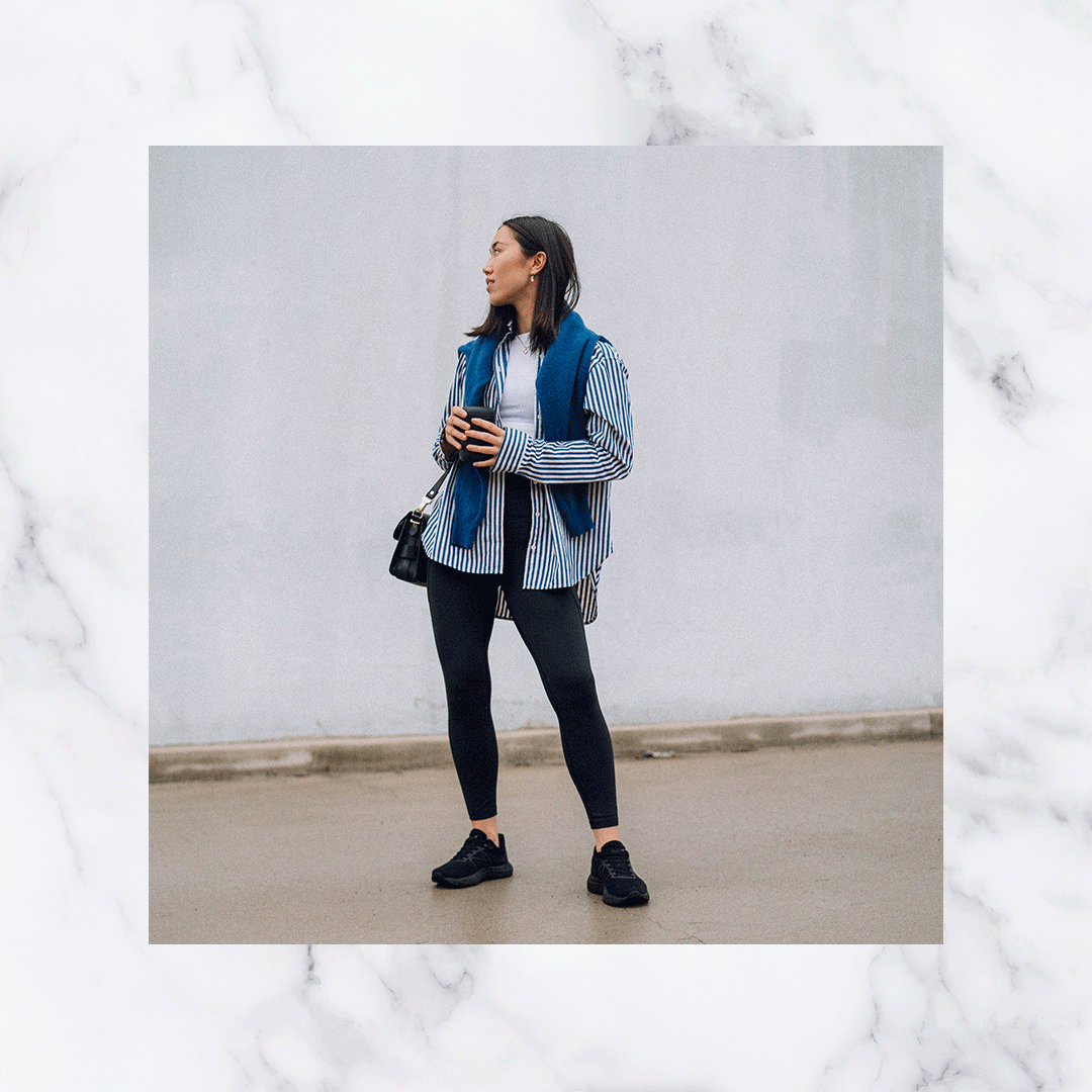 Woman standing up looking off to the side holding a coffee cup wearing New Balance 880's